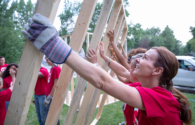 Personnes aidant à construire une charpente en bois pour une maison